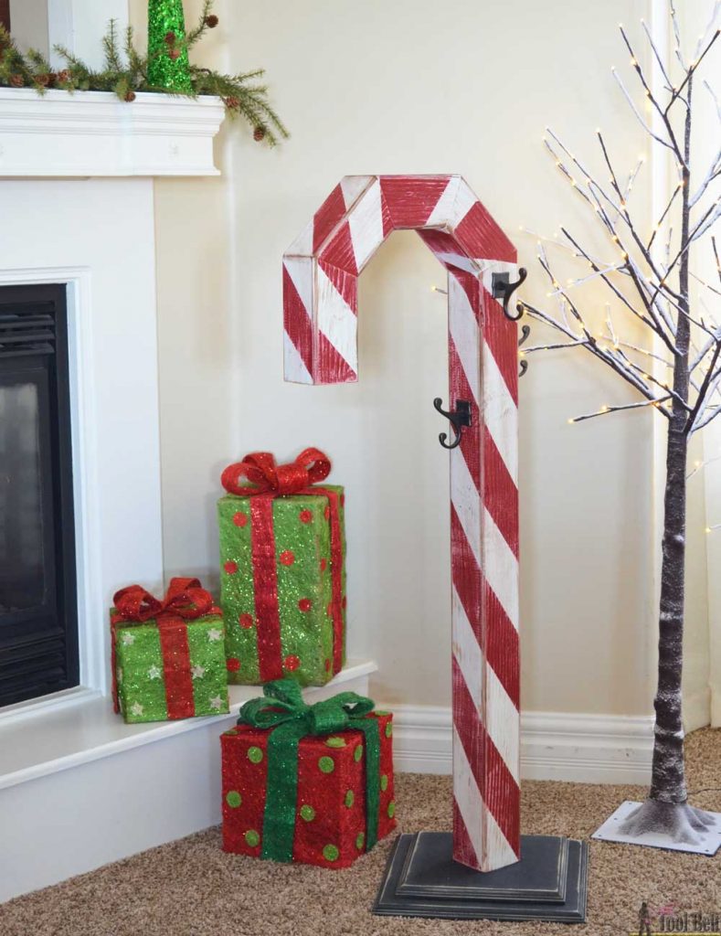 This is a perfect way to hang my Christmas stockings without a mantel! Free plans to build a DIY holiday Candy Cane stocking holder from a simple wood 4x4 post.