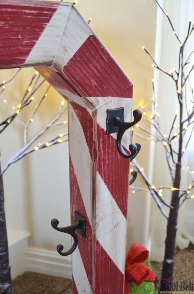 This is a perfect way to hang my Christmas stockings without a mantel! Free plans to build a DIY holiday Candy Cane stocking holder from a simple wood 4x4 post.