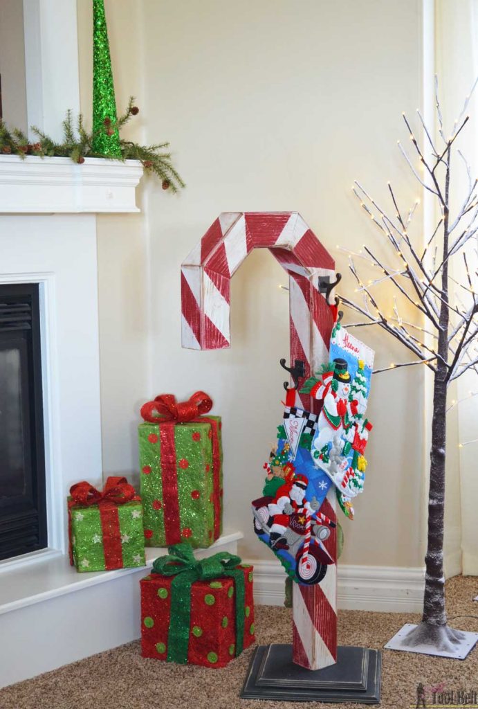 This is a perfect way to hang my Christmas stockings without a mantel! Free plans to build a DIY holiday Candy Cane stocking holder from a simple wood 4x4 post.