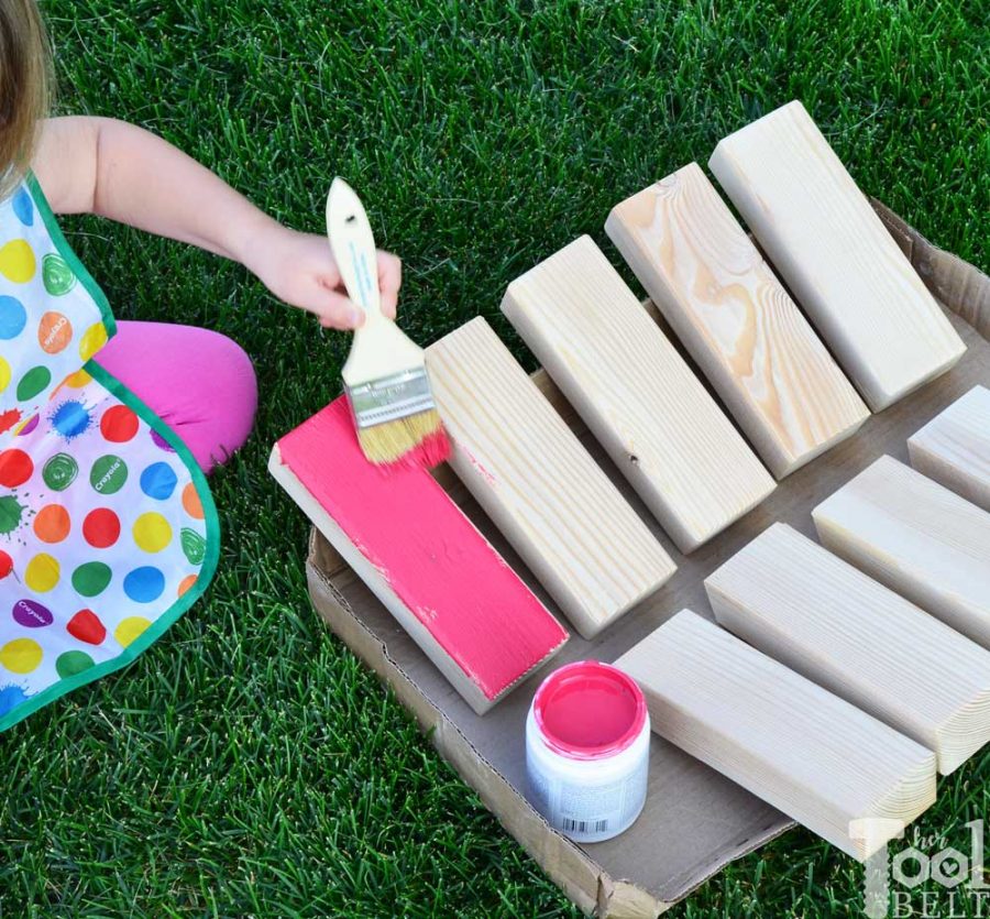 Painting the blocks colors. Make your own Giant Block Tower Builders yard game with a carrying crate that doubles as a playing stand. Add colored dice for a fun roll 'n go option to mix things up. 