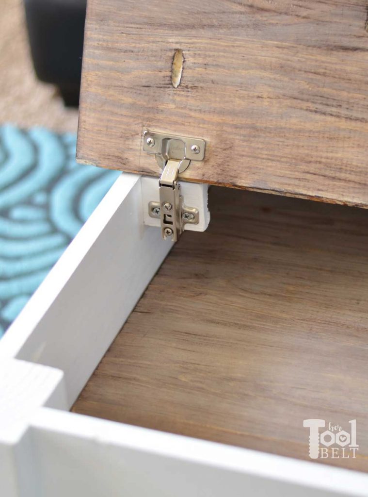 Simple farmhouse style coffee table with weathered wood top. This coffee table has a hidden gem, flip open the top for lots of storage space. Free plans